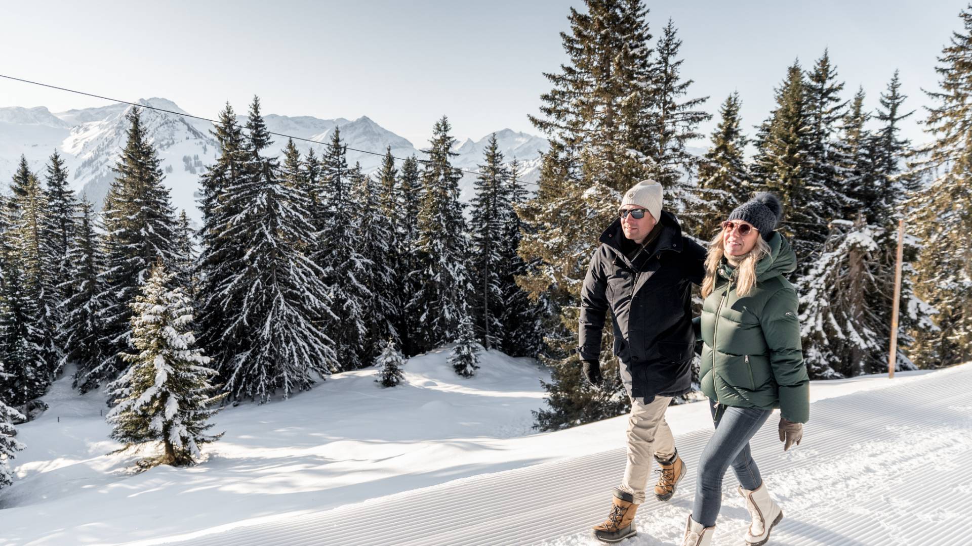 Paar spaziert durch Schnee in den schweizer Bergen in Gstaad