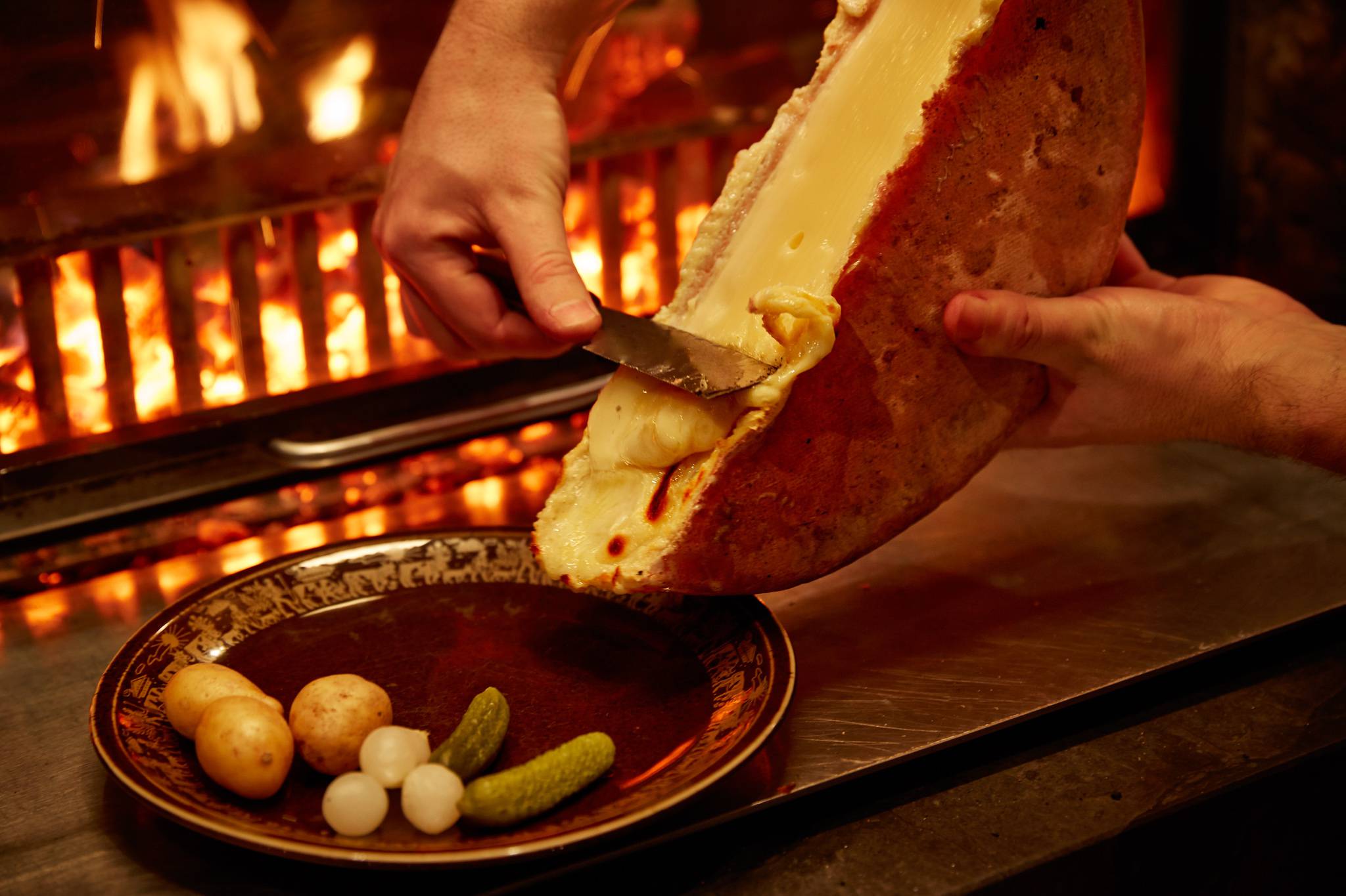 Melted on the wood fire: Swiss Raclette "on fire" - Hotel Gstaaderhof