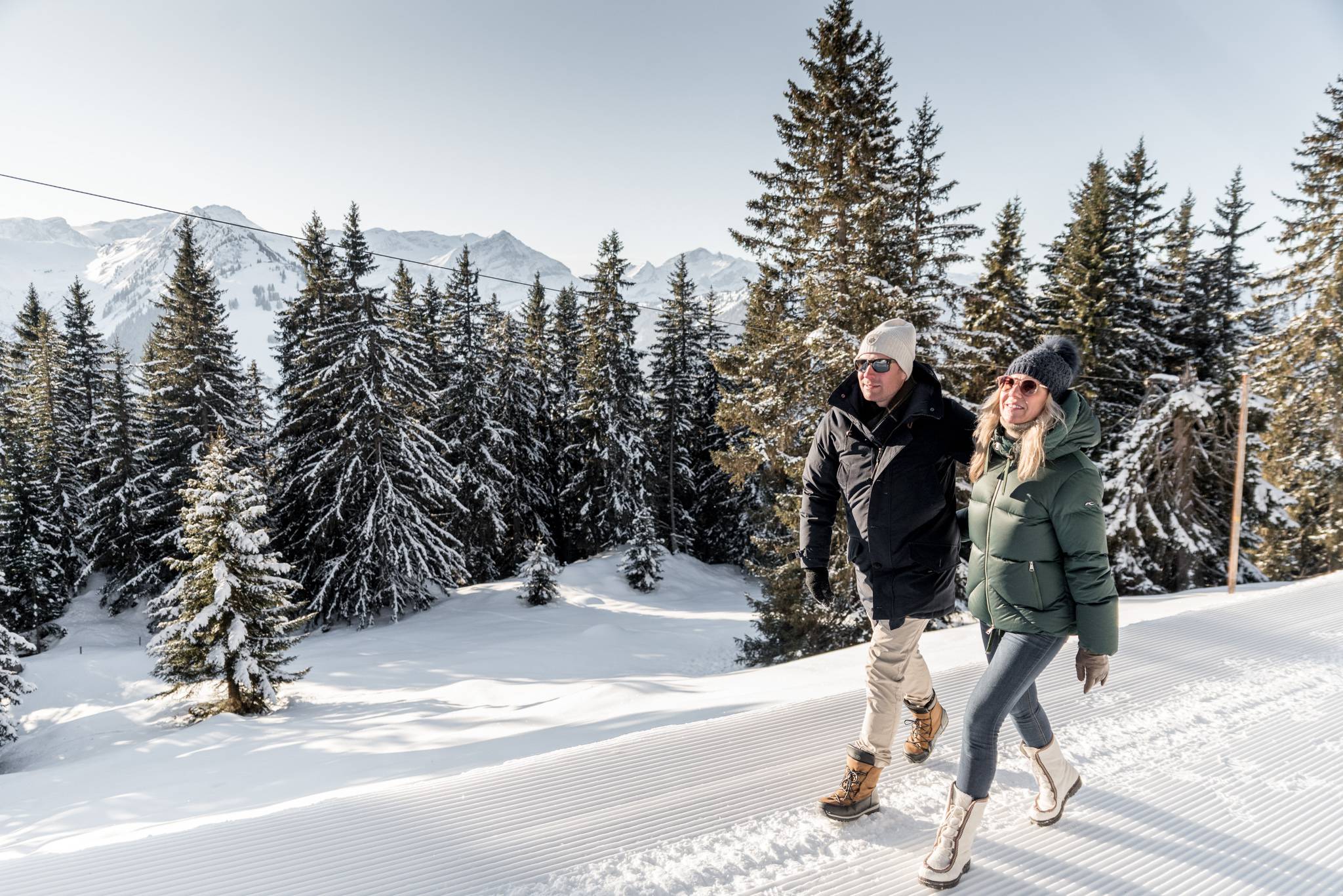 Paar spaziert durch Schnee in den schweizer Bergen in Gstaad