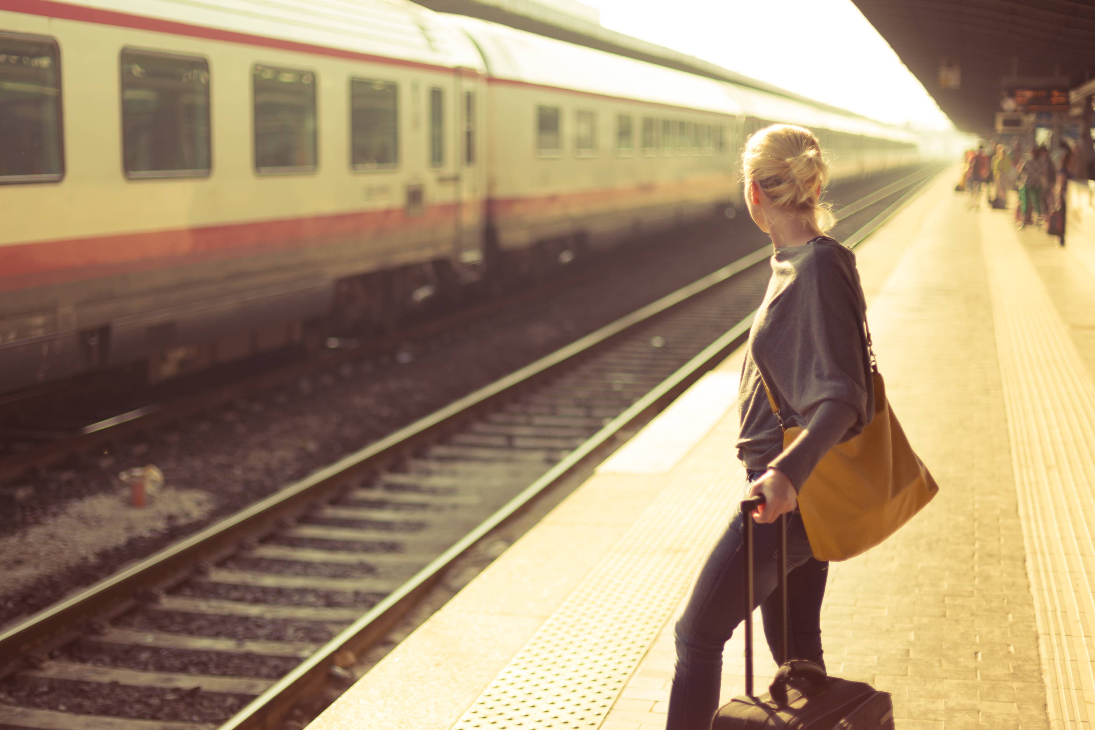 Frau wartet am Bahnhof auf den Zug