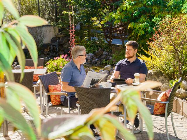 Vater und Sohn beim Kaffee trinken auf Terrasse des Gstaaderhof