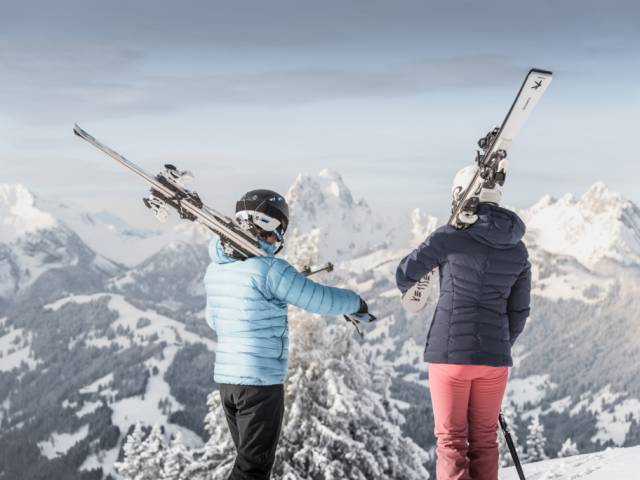 Skifahrer blicken auf schweizer Bergpanorama in Gstaad