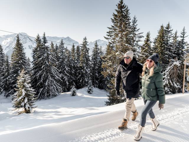 Paar spaziert durch Schnee in den schweizer Bergen in Gstaad