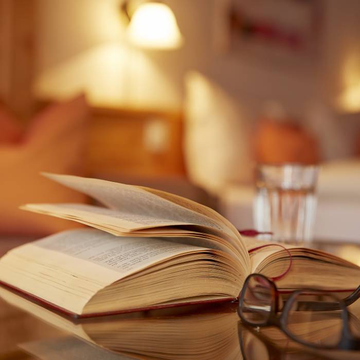 Buch und Brille liegen auf Tisch