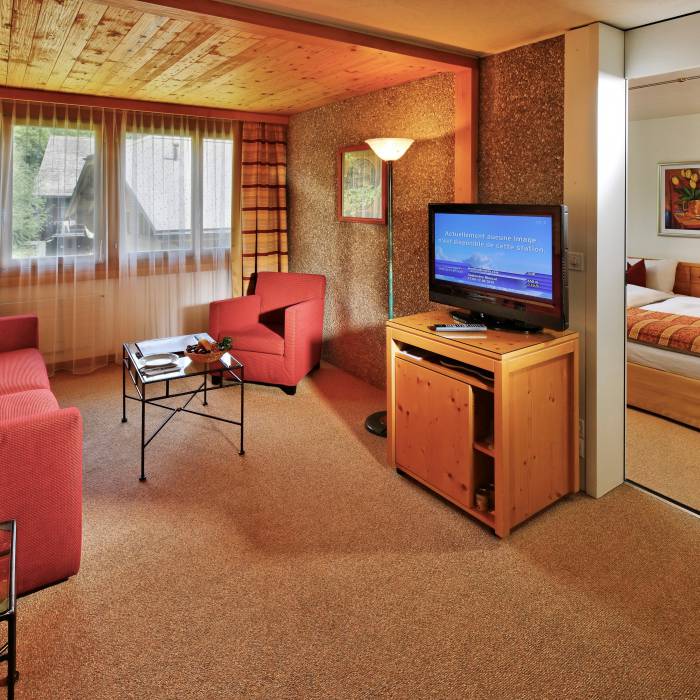 Familienzimmer mit Couch und TV im Hotel Gstaaderhof